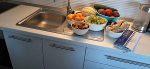 a counter with bowls of fruits and vegetables on a sink at Appartment IVA Kampor in Kampor +22 photos