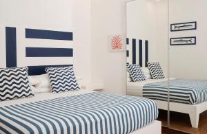 a bedroom with two beds with blue and white stripes at Casa Zara Sorrento City Center in Sorrento