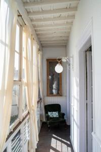 um corredor com uma cadeira num quarto com janelas em Mima's House · La Casa de Mima em Comillas