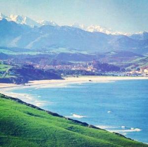 a view of a beach with mountains in the background at Mima's House · La Casa de Mima in Comillas