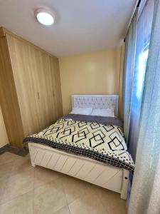 1 dormitorio pequeño con 1 cama en una habitación en Candy's Staycation en Thika