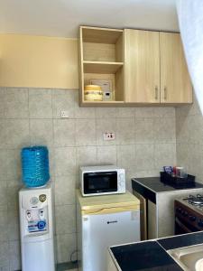 a kitchen with a microwave on top of a refrigerator at Candy's Staycation in Thika