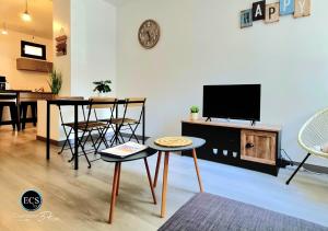 a living room with a tv and a table and chairs at "Cozy Zen" 1 grande chambre - Calme - Arrivée autonome - 6 pers - Parking gratuit in Tours