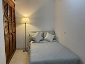 1 dormitorio con 1 cama con almohadas y lámpara en Apartamento Buenos Aires Medellin en Medellín
