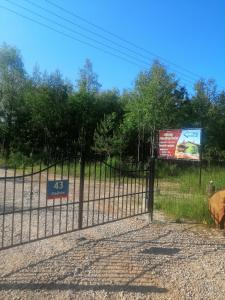una recinzione con un cartello sul lato di una strada di Agroturystyka Klimaty Poleskiego Parku a Cyców