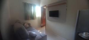 Una televisión o centro de entretenimiento en Suíte Ponta da Areia