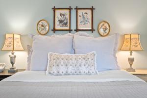 1 dormitorio con 1 cama blanca y 3 cuadros en la pared en Somerset Cottage at Ivy Cottages, en Crozet