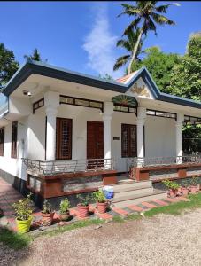 バルカラにあるBhaskar villas homestaysの鉢植えの白屋
