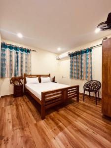 1 dormitorio con 1 cama y 1 silla en Bhaskar villas homestays en Varkala