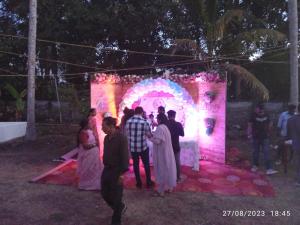a group of people standing in front of a lit up arch at Bhaskar villas homestays in Varkala