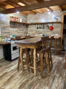 una cocina con una gran mesa de madera y sillas en Cabaña Cercana al Centro en El Bolsón