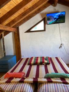 1 dormitorio con 1 cama y TV en la pared en Cabaña Cercana al Centro en El Bolsón