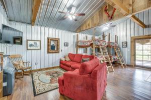 a living room with a red couch and a chair at Rustic Lake City Studio Near Ichetucknee Springs! in Lake City