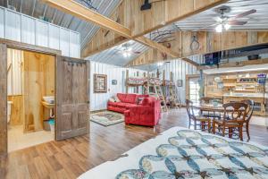 a living room with a red couch and a table at Rustic Lake City Studio Near Ichetucknee Springs! in Lake City