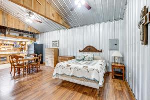 a bedroom with a bed and a table and a kitchen at Rustic Lake City Studio Near Ichetucknee Springs! in Lake City