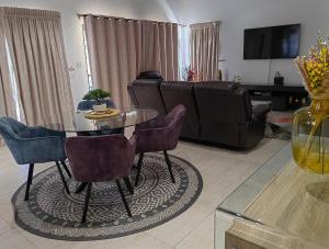 een woonkamer met een tafel en een bank bij Sebs Chalet in Hartbeespoort