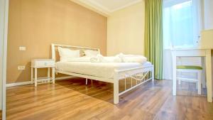 a bedroom with a white bed and a window at Central Maximus Apartment in Braşov