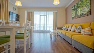 ブラショヴにあるCentral Maximus Apartmentのリビングルーム(黄色のソファ、テーブル付)
