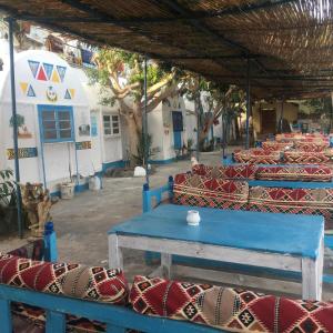 eine Gruppe von Tischen und Stühlen in einem Gebäude in der Unterkunft Nubian Beach - حسن فوكس in Assuan
