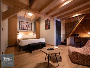 pokój hotelowy z łóżkiem i schodami w obiekcie La Grange des Eulets w mieście Bourg-Saint-Maurice