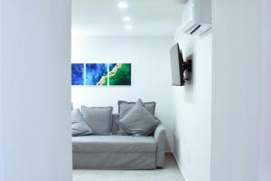 Una sala de estar con un sofá y un televisor. en Cico Art Suite, en Nápoles