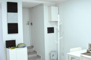 una cocina con paredes blancas y una escalera blanca en Cico Art Suite, en Nápoles