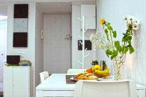 una mesa con un plato de fruta y un jarrón de flores en Cico Art Suite, en Nápoles
