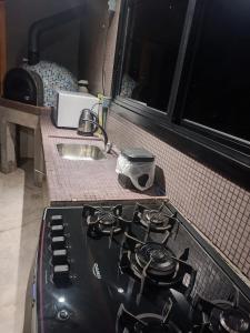 a stove top in a kitchen with a sink at Casa com piscina em Torres in Torres +28 photos