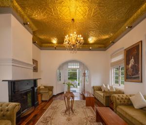 sala de estar con techo dorado en The Clovelly Bungalow, en Nuwara Eliya