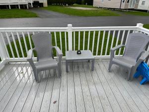 two chairs and a table on a deck at "Malton" LG27 Pet Friendly in Shanklin