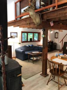 ein Zimmer mit einem Wohnzimmer mit einem Sofa und einem Tisch in der Unterkunft Quiet cottage on wooded property in Lusby