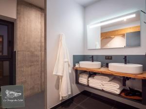 y baño con 2 lavabos, espejo y toallas. en La Grange des Eulets, en Bourg-Saint-Maurice