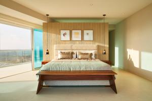 a bedroom with a large bed and a large window at Luxury 3bdr Beachfront Condo, Peninsula Ixtapa in Ixtapa