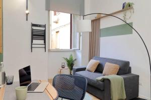 a living room with a couch and a table with a laptop at Gazometro Apartment SelfCheck-in in Rome