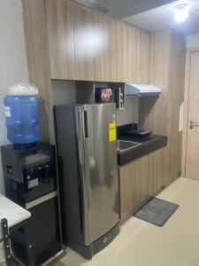 a kitchen with a refrigerator and a sink at Staycation at SMDC Cheers Residences Marilao in Marilao