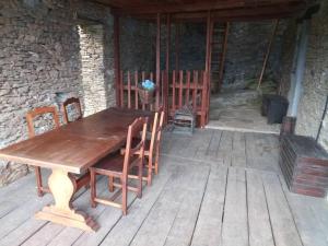une table et des chaises en bois sur une terrasse en bois dans l'établissement Shangri-La, à Villar Pellice