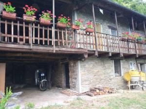 a building with a balcony with potted plants on it at Shangri-La in Villar Pellice