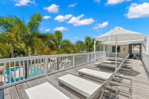 een terras met ligstoelen en een parasol bij Hotel Cabana Clearwater Beach in Clearwater Beach