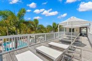 a deck with lounge chairs and an umbrella at Hotel Cabana Clearwater Beach in Clearwater Beach