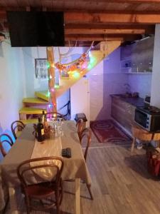 a dining room with a table and a kitchen at Kuca za odmor Magicna livada in Podgrab