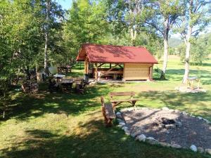 a cabin with a picnic table and a fire pit at Kuca za odmor Magicna livada in Podgrab