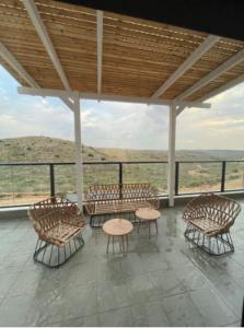 a room with chairs and tables and a view of the desert at דירת רויאלטי עם חצר ונוף לשמורת טבע בפסגות אפק in Rosh Ha‘Ayin