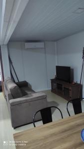 uma sala de estar com um sofá e uma televisão em Hermoso amplio casa container Balneario Buenos Aires em Balneario Buenos Aires