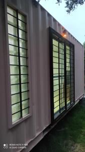 2 ventanas con persianas en el lateral de un edificio en Hermoso amplio casa container Balneario Buenos Aires, en Balneario Buenos Aires