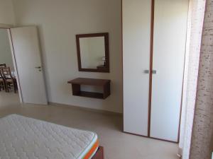 a bedroom with a bed and a mirror on the wall at Aati Apartment in Durrës