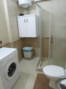 a bathroom with a washing machine and a toilet at Aati Apartment in Durrës