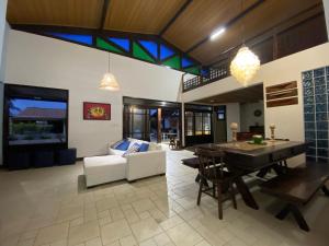 a living room with a table and a dining room at Casa Familiar 5 Suítes Porto de Galinhas in Porto De Galinhas