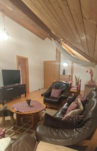 een woonkamer met lederen meubels en een piano bij Apartment ANDA in Bad Kleinkirchheim