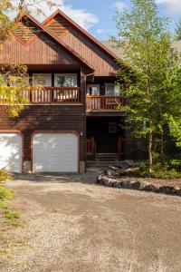 een groot huis met een garage en een veranda bij Polar Peak by Fernie Central Reservations in Fernie