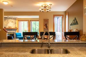 a kitchen with a sink and a living room at Polar Peak Lodges by Fernie Central Reservations in Fernie